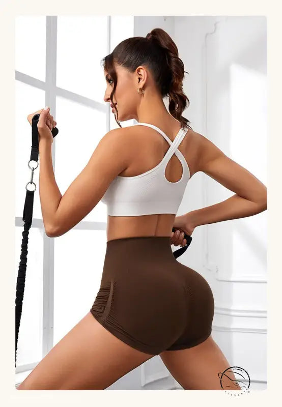 Woman exercising in high waist peach hip fitness pants