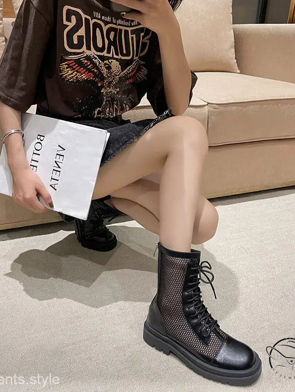 Woman in hollow Langry boots, black band t-shirt, shorts, holding book with free shipping