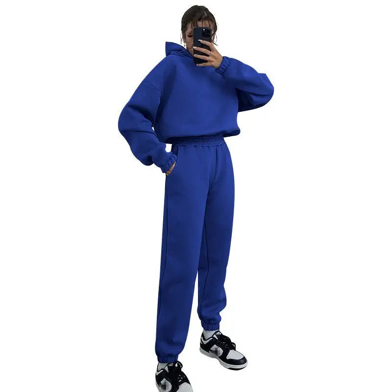 Person in bright blue hooded long sleeve sweater and sneakers taking mirror selfie for winter hooded casual wear