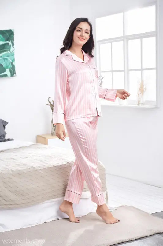 Woman wearing pink imitated silk striped lounge set in bright room, perfect striped casual homewear