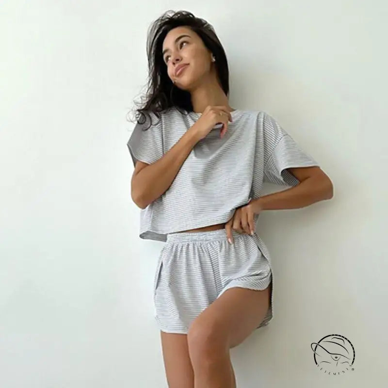 Woman in knitted loose pajamas: grey white striped crop top and shorts