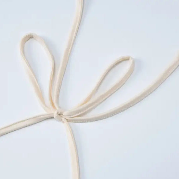 Tied beige fabric straps on lace vest pleated skirt set for a stylish summer look