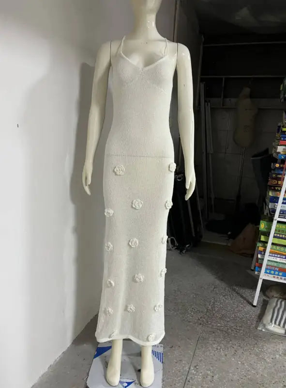 White floral-embellished backless bodycon maxi dress displayed on a mannequin