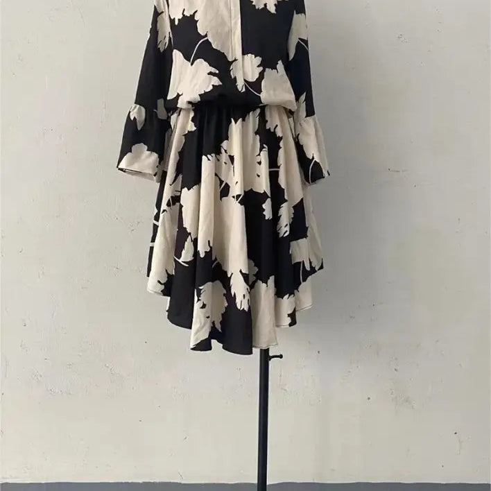 Black and white floral print dress with long sleeves and a flared skirt.