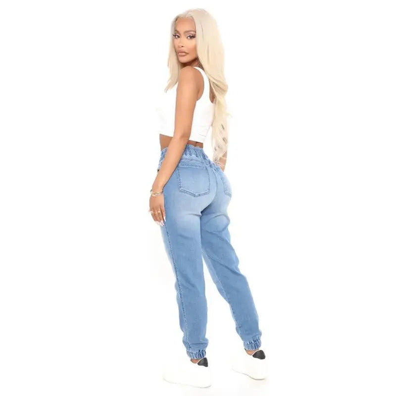 Women’s light wash denim joggers with high elasticized waist and ribbed cuffs for light blue office style