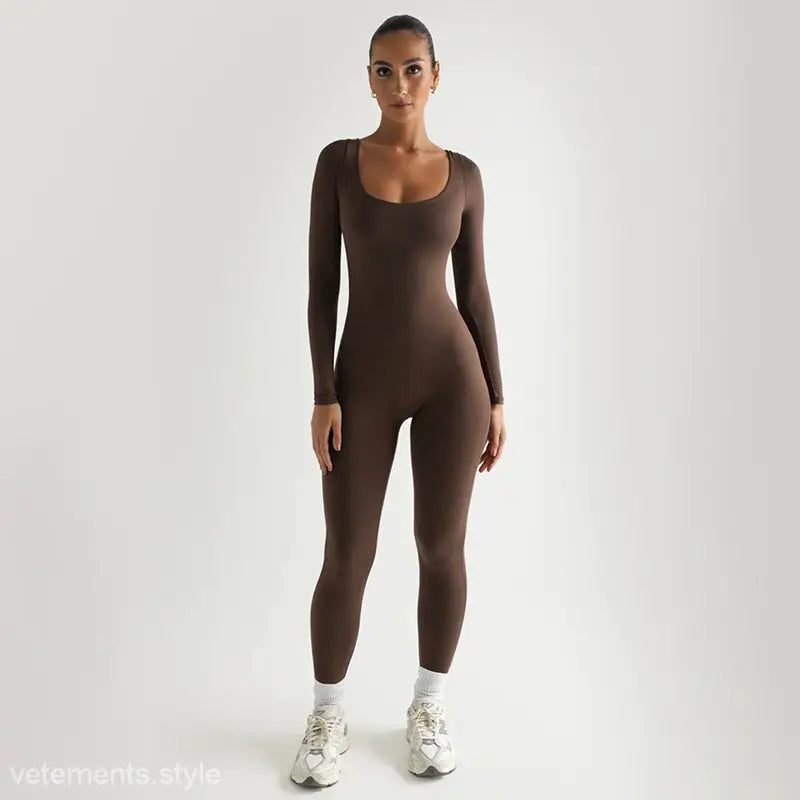 Brown long-sleeved bodysuit styled with white sneakers, complementing a light gray soft jumpsuit