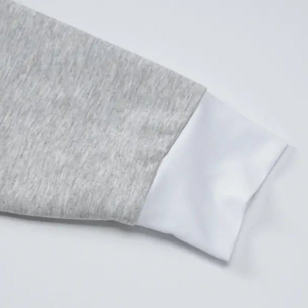 Sleeve of a gray and white two-toned garment.