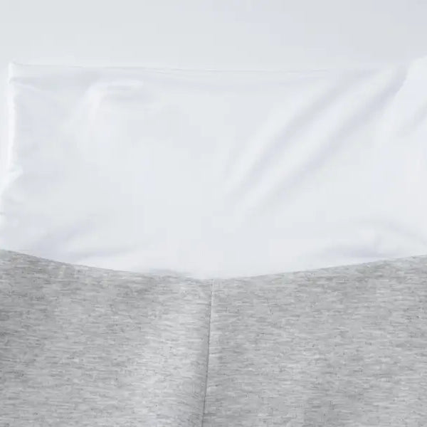 White pillow resting on gray fabric or bedding.