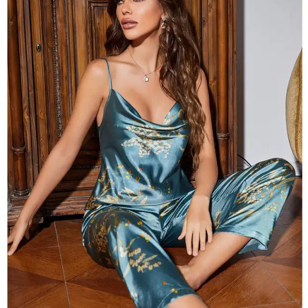 Woman wearing teal ice silk pajamas with gold floral patterns from Light Green Cherry collection