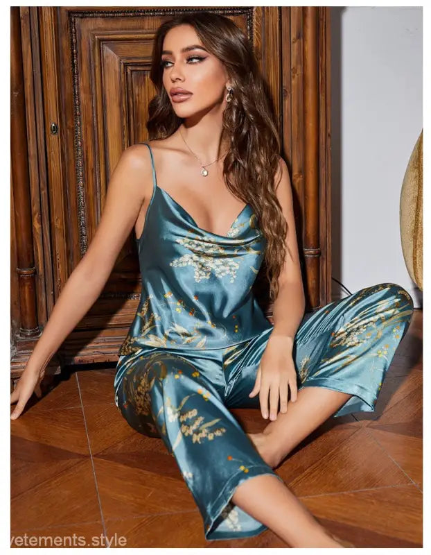 Woman wearing teal ice silk pajamas with gold floral patterns from Light Green Cherry collection