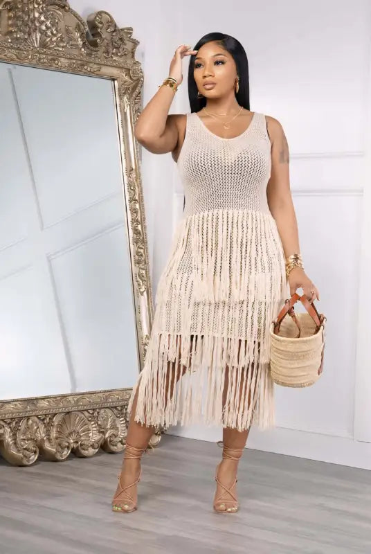 Woman modeling a light green knitted beach dress with elegant fringe detail