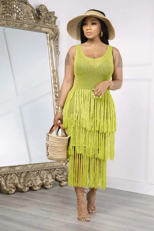 Woman in a light green knitted beach dress with elegant fringe detail