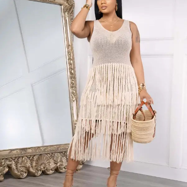 Woman in a light green knitted beach dress with elegant fringe detail for summer wear