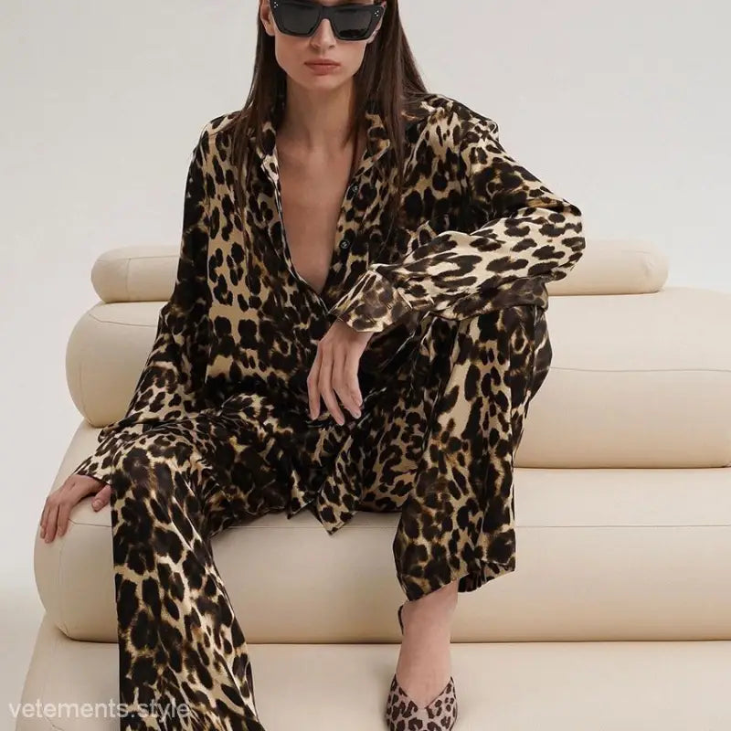 Luxury leopard pajamas featuring a leopard-print pantsuit worn by a woman on a cream couch