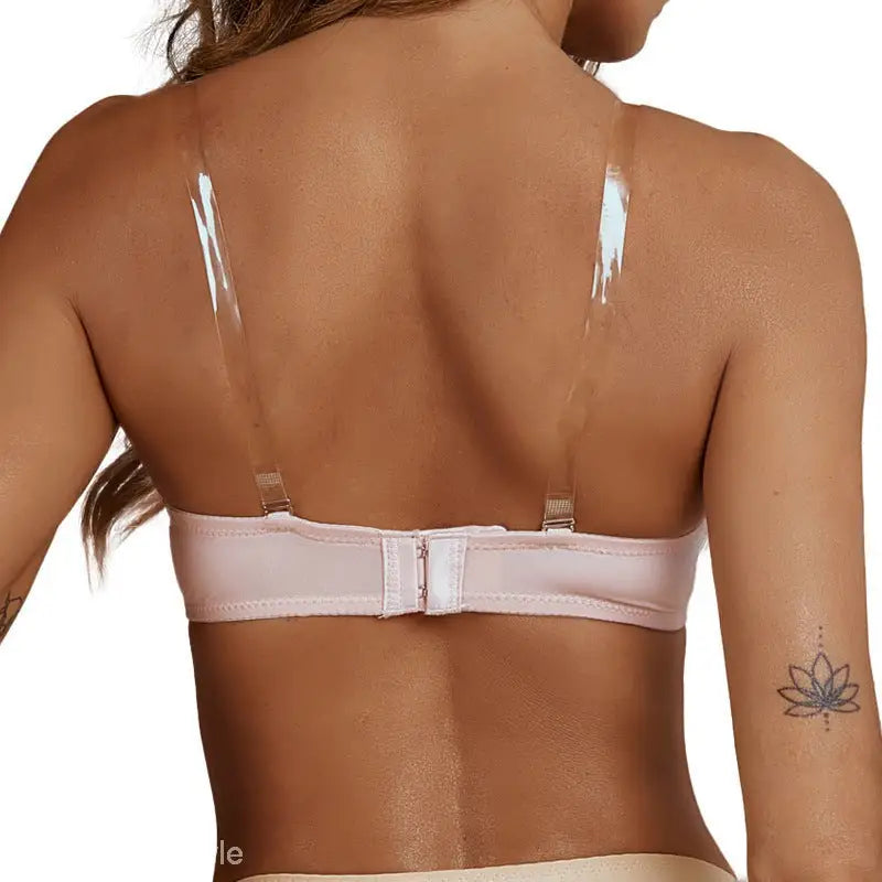 Woman’s back in light pink wireless bra with clear shoulder straps and removable padding