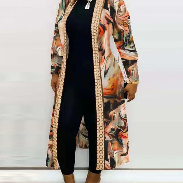 Woman’s black jumpsuit complemented by a long sleeve printed cardigan shawl