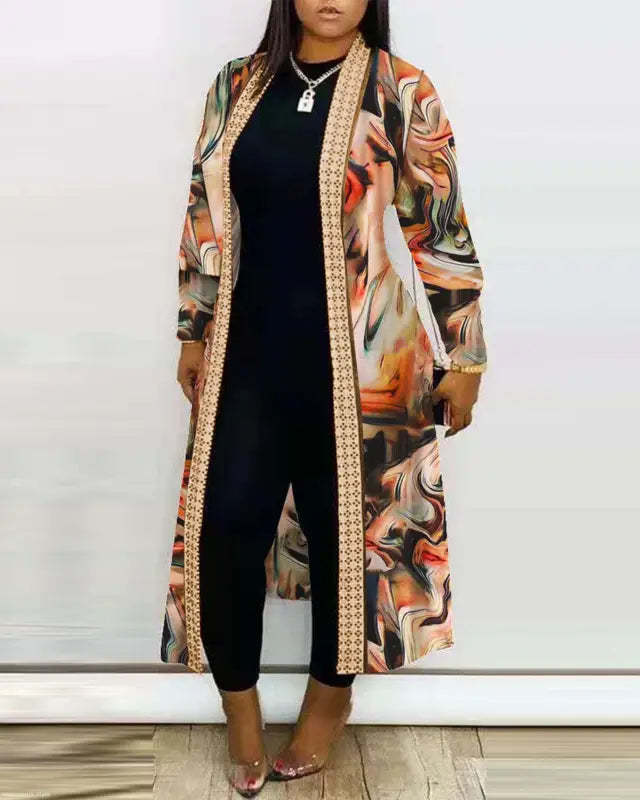 Woman’s black jumpsuit complemented by a long sleeve printed cardigan shawl