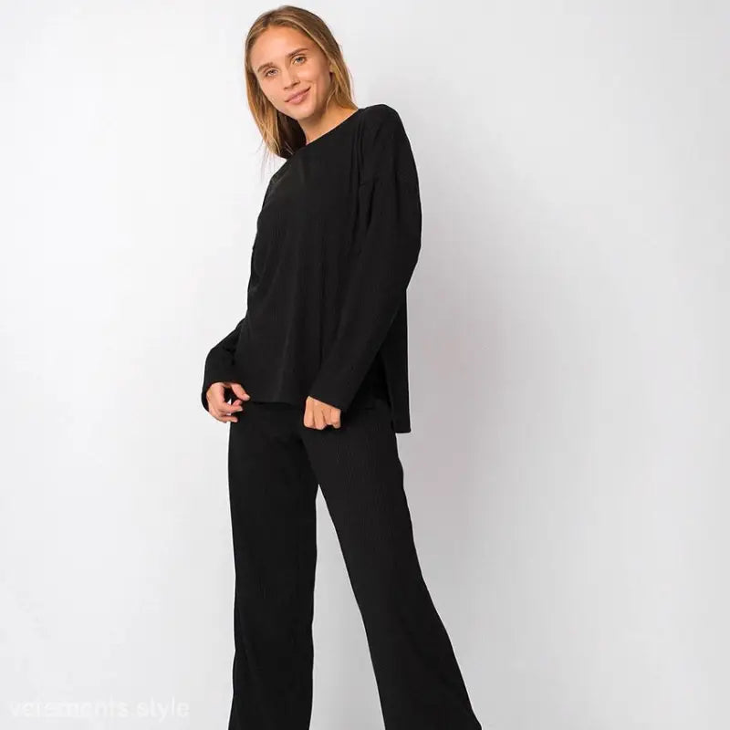 Woman wearing black long-sleeved top and wide-leg pants in loose comfortable pajamas two piece set