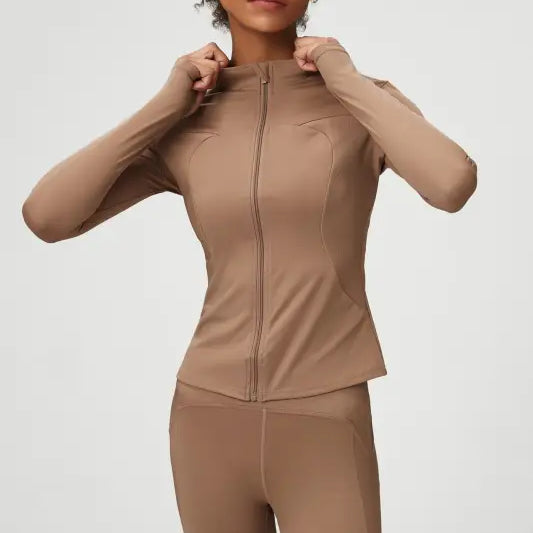 Woman in tan athletic wear showcasing Matcha Green Long Sleeve Coat with tight waist design