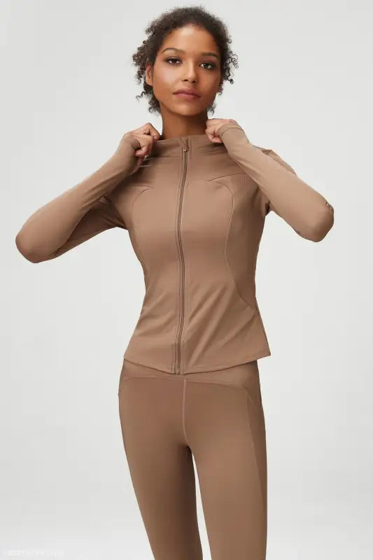Woman in tan athletic wear showcasing Matcha Green Long Sleeve Coat with tight waist design