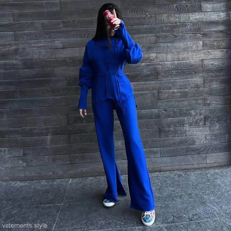 Bright blue full-body jumpsuit with long sleeves and wide legs, part of modern hoodie sets