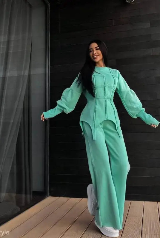 Woman in vibrant mint green modern hoodie sets with voluminous sleeves and wide-leg pants