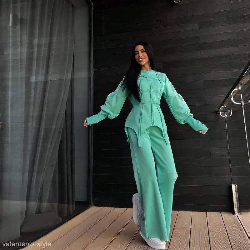 Woman in vibrant mint green modern hoodie sets with voluminous sleeves and wide-leg pants