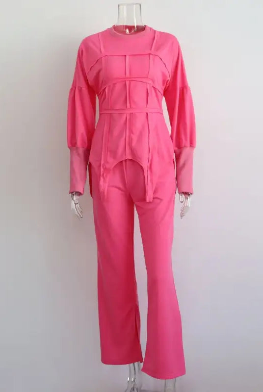 Bright pink jumpsuit with long sleeves and flared pants displayed on a mannequin, ideal for modern hoodie sets and pullover styles