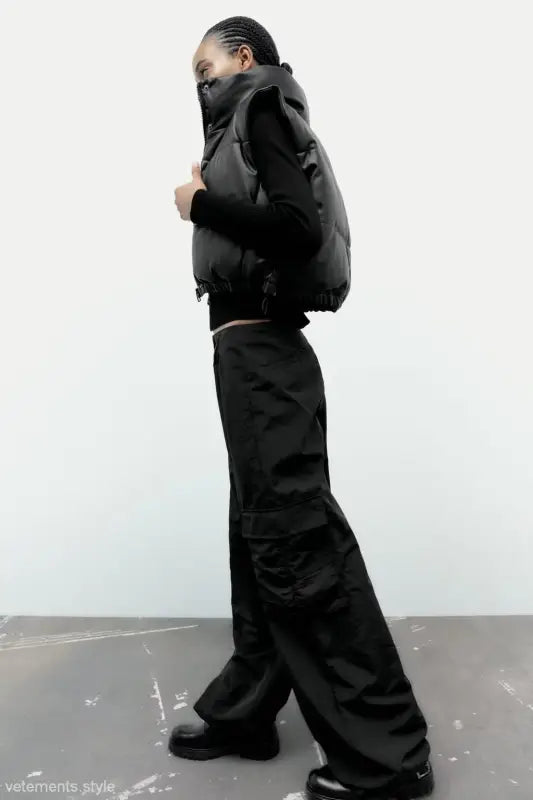 Black puffer vest with cargo pants paired with a modern short faux leather jacket