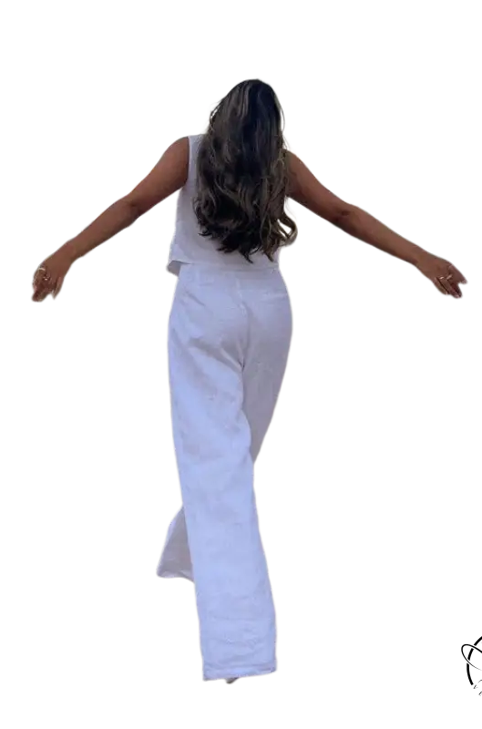 Woman in Monaco summer outfit walking on dirt path with arms outstretched