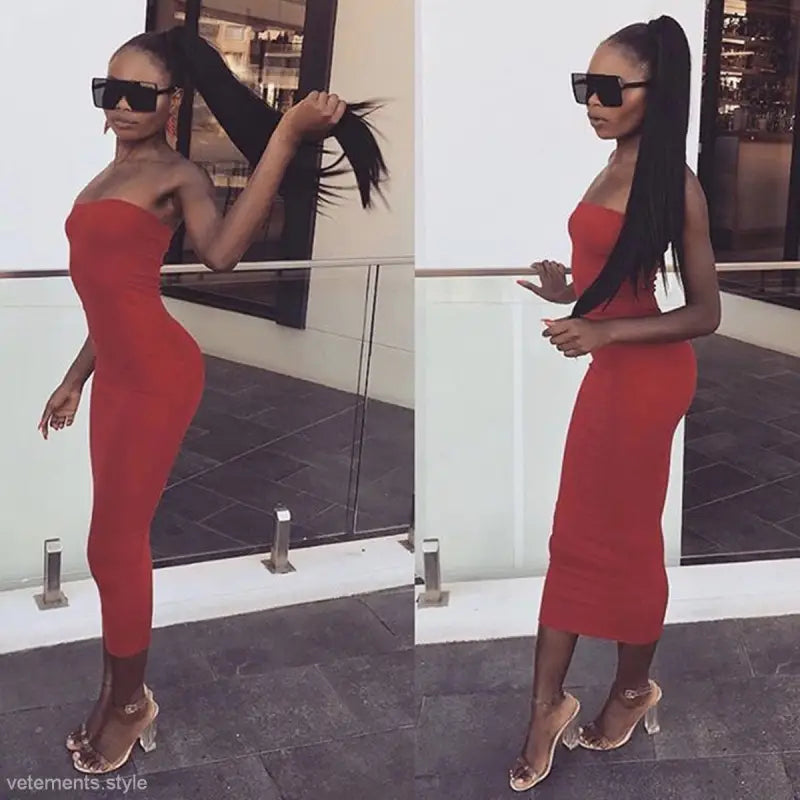 Woman in a confident pose wearing a navy blue long beach dress and sunglasses