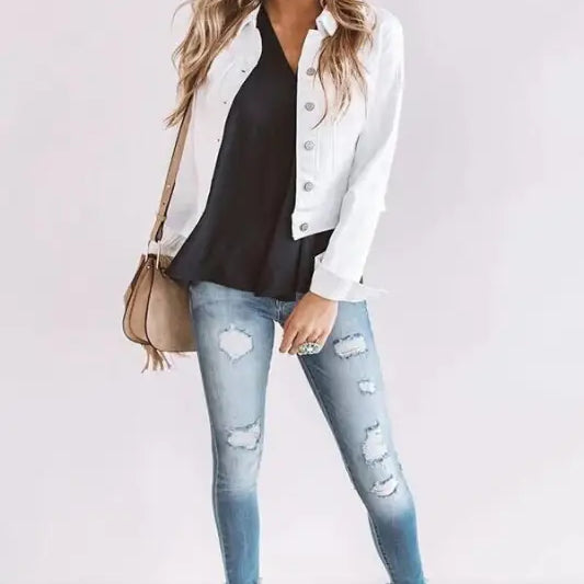 Woman wearing navy blue casual denim jacket with ripped jeans and beige shoes for autumn winter wear