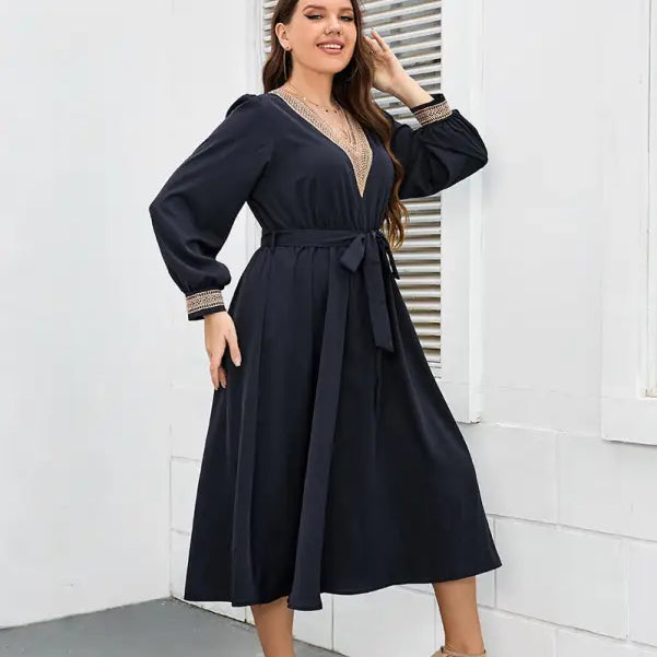 Navy blue wrap dress with long sleeves and a belted waist.
