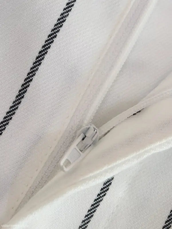 White suit with black striped fabric and a white zipper, ideal for office style slim look