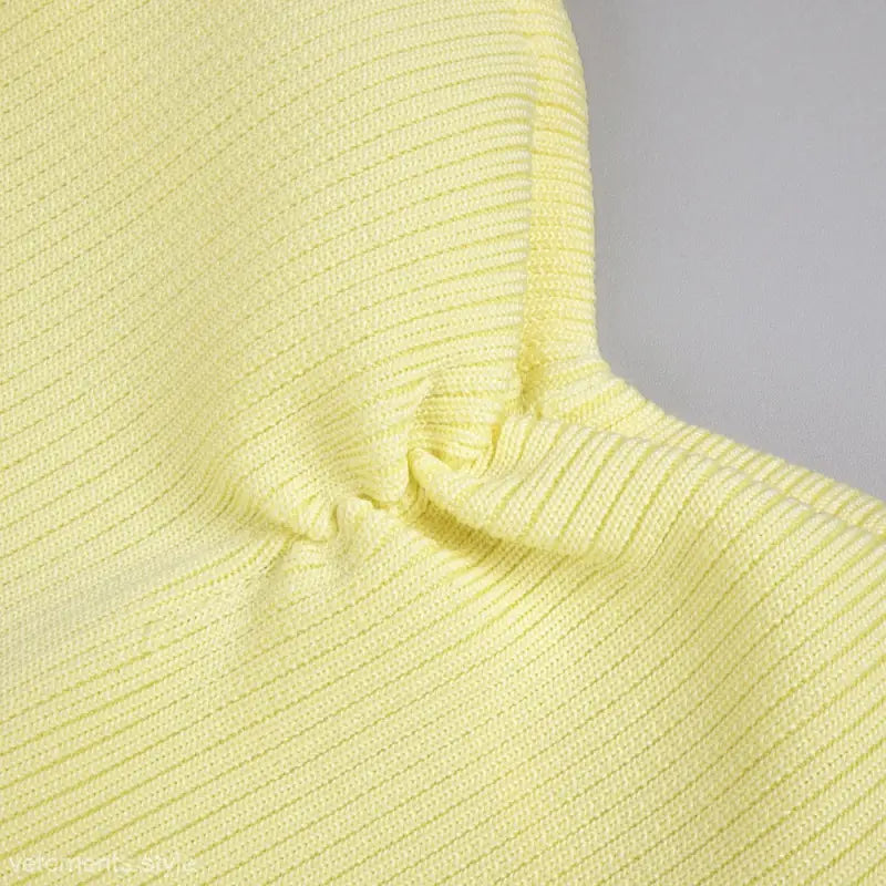 Close-up of pale yellow ribbed knitted fabric with gathering detail from the Yellow Sold Langry dress