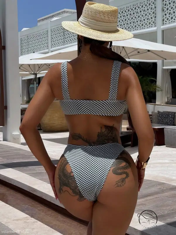 Woman in plaid printed sexy bikini with dragon tattoos and straw hat