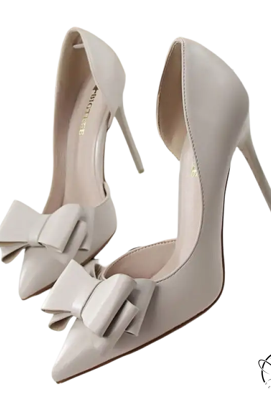 Elegant sweet high-heeled pumps in ivory patent leather with pointed toe and bow