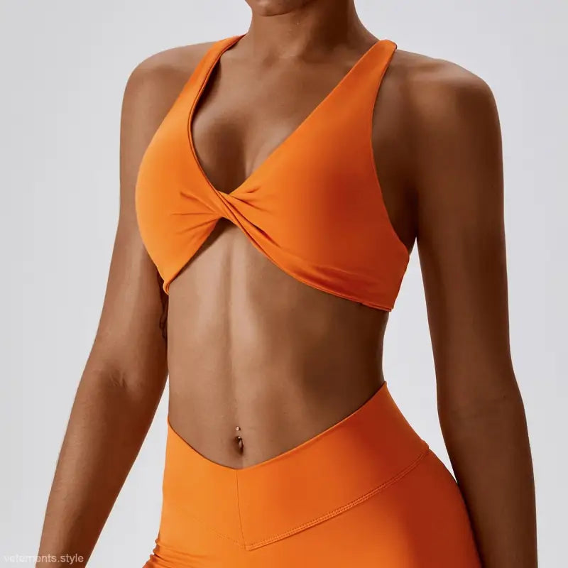 Orange twisted-front sports bra from Quick Drying Yoga collection in tropical orange and dark reddish purple