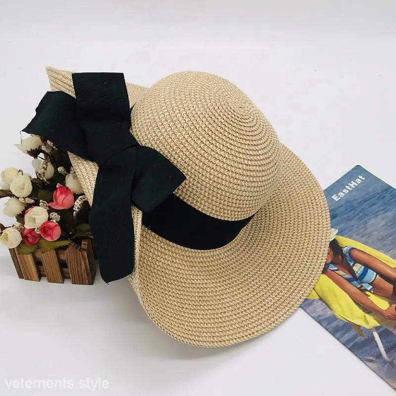 Straw sun hat with black ribbon designed as a big bow sunshade for stylish elegance