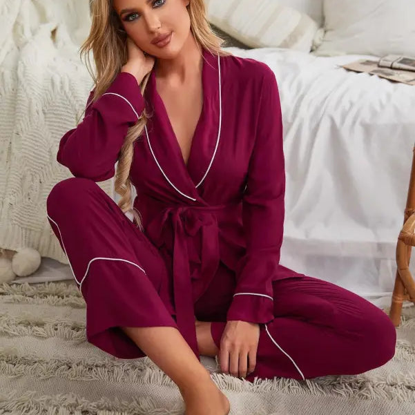 Woman in burgundy red cardigan pajamas with white piping on plush rug, perfect for spring and fall