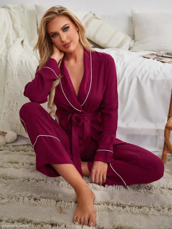 Woman in burgundy red cardigan pajamas with white piping on plush rug, perfect for spring and fall