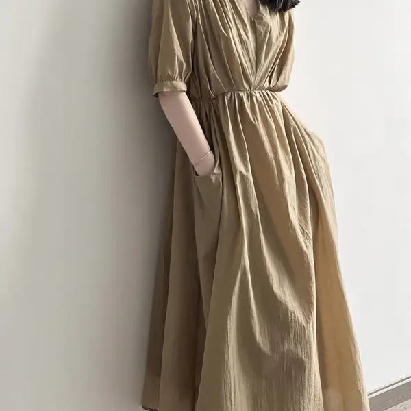Flowy beige retro v neck pleated dress with elbow-length sleeves and cinched waist