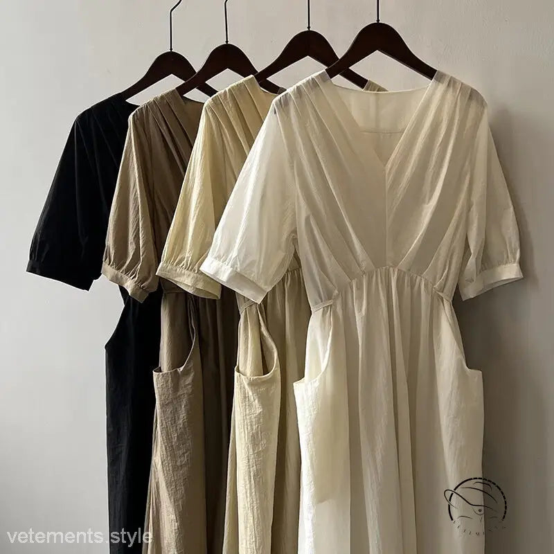 Four neutral retro v neck pleated midi dresses on hangers