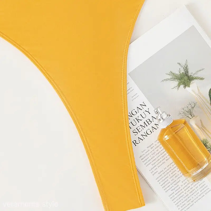 Yellow glass bottle of liquid beside text for Royal Blue Backless Sexy Swimsuit with free shipping