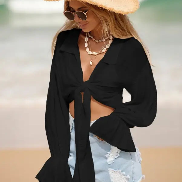 Woman wearing a royal blue boho tie sleeve top and straw hat for summer vacation