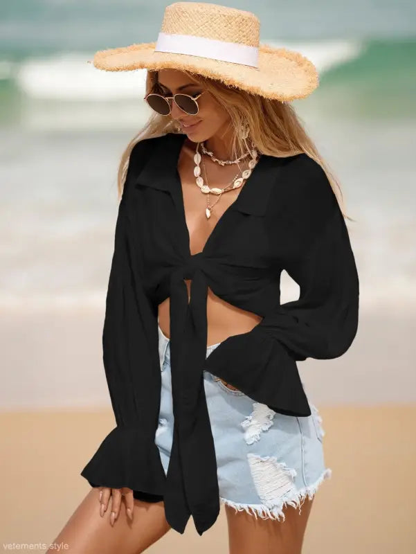 Woman wearing a royal blue boho tie sleeve top and straw hat for summer vacation