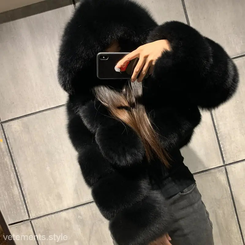 Woman in royal blue faux fur coat taking mirror selfie