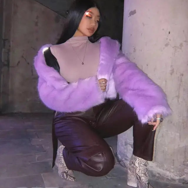 Woman in royal blue faux fur coat crouching elegantly