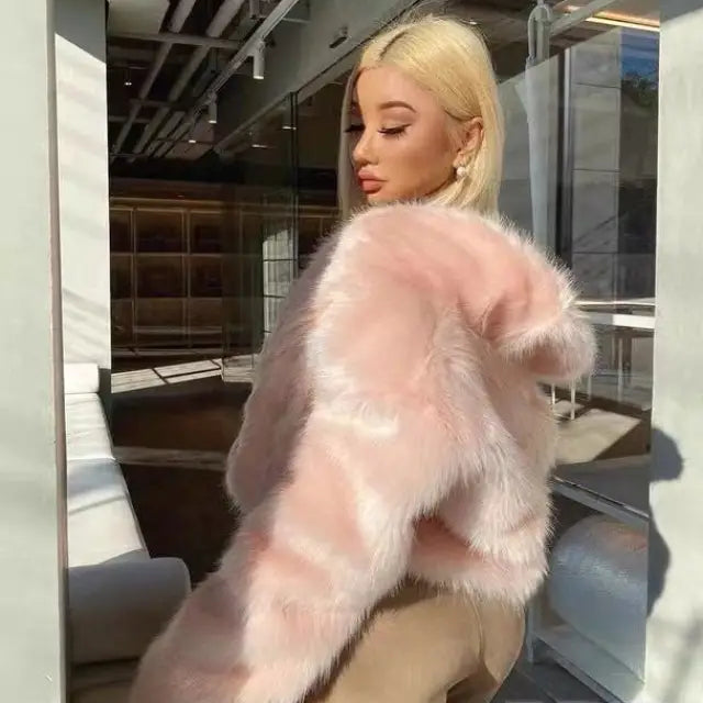 Woman in platinum blonde hair wearing royal blue faux fur coat