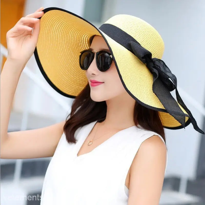 Wide-brimmed yellow straw sun hat with black ribbon trim, matching navy blue solid and light purple accents